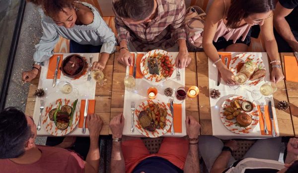 multiracial-friends-eating-food-in-restaurant.jpg